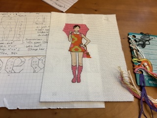 Cross stitch work in progress of a 1960s mod lady